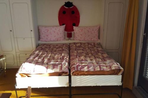 1 dormitorio con 1 cama con cabecero rojo en Studio Brisiblick - CharmingStay, en Flumserberg