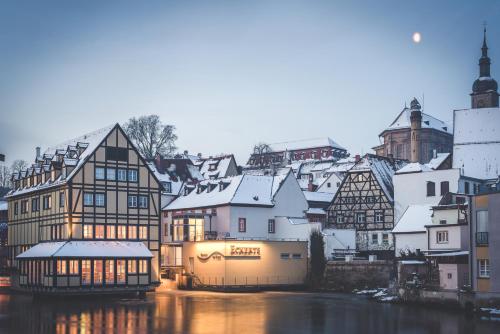 a town with snow covered buildings and a river at Hotel Nepomuk in Bamberg