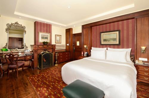 a bedroom with a large bed and a desk and a dining room at Mayfair Darjeeling in Darjeeling