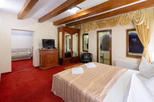a hotel room with a bed and a television at Casa Danielescu in Târgu Jiu