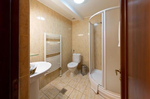 uma casa de banho com um WC, um lavatório e um chuveiro em Casa Danielescu em Târgu Jiu
