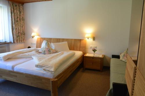 a bedroom with a large bed and a couch at Haus Tirolerland in Mayrhofen