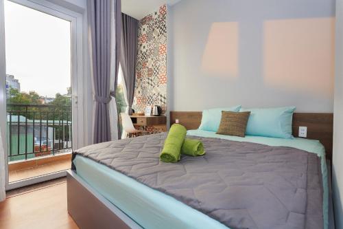 een slaapkamer met een bed met twee groene kussens erop bij Home Peace Home - District 1 in Ho Chi Minh-stad