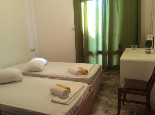 two beds in a room with a table and a chair at Kalliopi in Agios Nikolaos