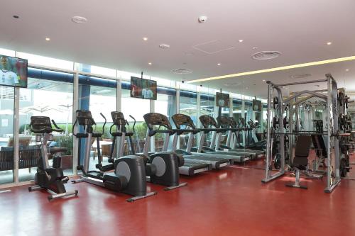a gym with a bunch of treadmills and ellipticals at Novotel Jazan in Jazan