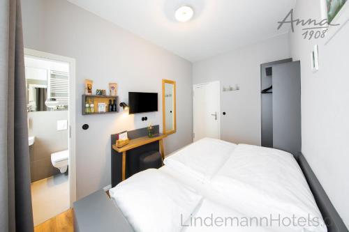 a bedroom with a white bed and a bathroom at Anna 1908 in Berlin