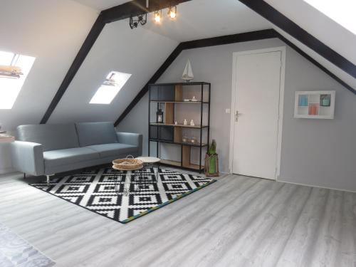 sala de estar con sofá y alfombra en Bel appartement paimpol, en Paimpol