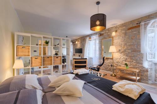 una camera con un grande letto e un muro di pietra di Luxury Apartment Fabris a Rovigno (Rovinj)
