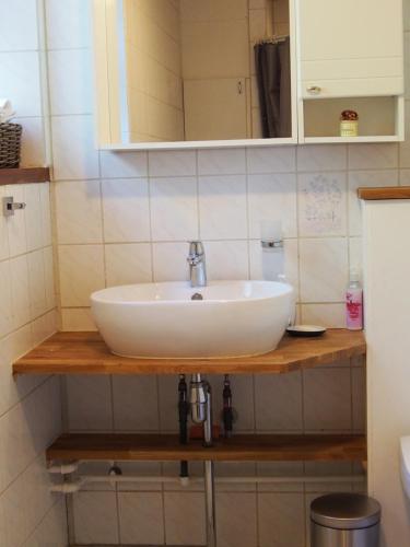 un lavandino bianco su un bancone in legno in bagno di Labaek B&B a Holbæk