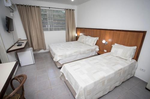 Habitación de hotel con 2 camas y TV en Casa Poletto, en Morretes