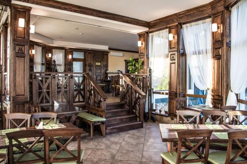 a restaurant with wooden walls and wooden tables and chairs at Синевирський Перевал in Synevyr