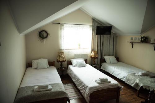 a bedroom with two beds and a window with a tv at Lodownia in Szydłowiec