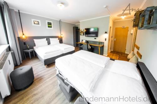 a hotel room with two beds and a desk at Anna 1908 in Berlin