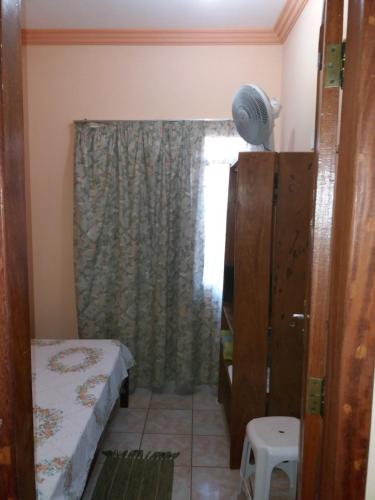 uma pequena casa de banho com uma cama e uma janela em Aconchego Canastra Hotel em Vargem Bonita