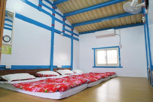 Habitación con cama grande con almohadas rojas. en 嘉義泊岸居民宿 en Lucao