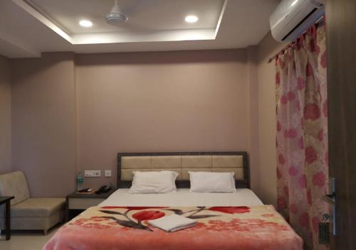 a bedroom with a bed and a couch and a bed sidx sidx sidx at Hotel Raj Palace in Dibrugarh