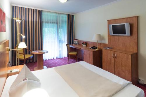 a hotel room with a bed and a desk at Hotel St. Georg in Bad Aibling