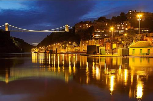 a bridge over a body of water at night at Beautiful large victorian waterfront house in Bristol