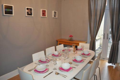 a dining room table with a white table cloth and chairs at Beautiful large victorian waterfront house in Bristol