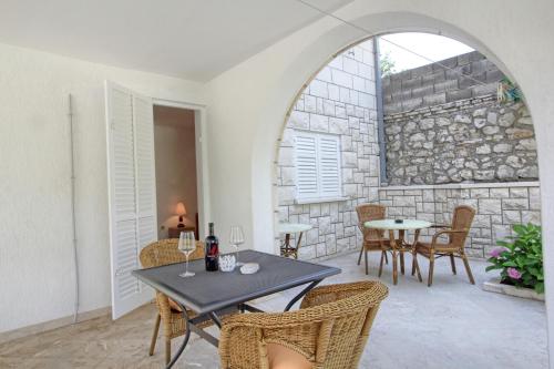 a patio with a table and chairs and a stone wall at Apartments Nine Slano in Slano