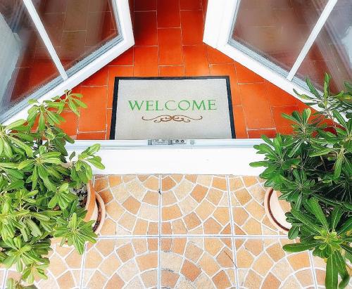 a welcome sign in a room with some plants at Holiday Home Dunja in Opatija