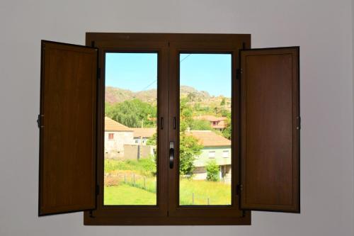 an open window with a view of a city at Just Natur Guesthouse in Castro Laboreiro