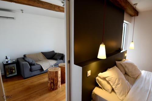 a room with a bed and a living room with a couch at Le Domaine de Baulieu, Singuliers Hotels in Auch