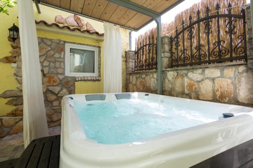 a hot tub in a room with a balcony at Green house, WI-FI, FREE PARKING, GARDEN, HOT TUBE in Peroj