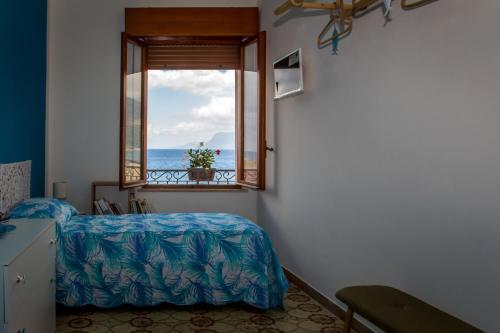 a bedroom with a window with a view of the ocean at Piana delle Galee in Scilla