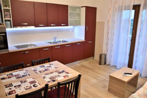 cocina con mesa, fregadero y armarios en Apartmani Diana, en Novigrad Istria