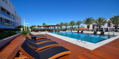 een rij banken naast een zwembad bij Solar Tambau Residencial in João Pessoa