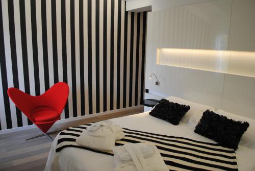 a bedroom with a red chair and a bed at Hotel Borgo Pantano in Siracusa