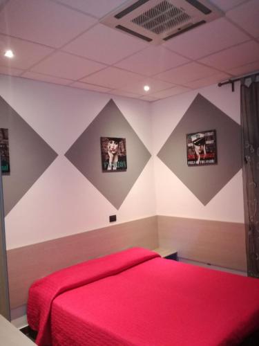 a bedroom with a red bed and pictures on the wall at B&B Adriatico in Giulianova