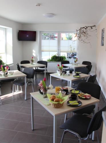 a restaurant with tables and chairs with food on them at Pension Am Ziegelwall in Bautzen