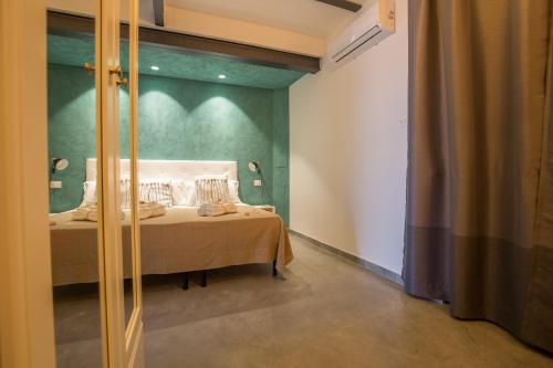 a bedroom with a bed with a green wall at Al Faro Bianco B&B e Residence con parcheggio in Vasto