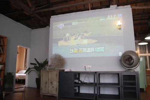 a large screen with a presentation on a wall at Tainan MacArthur Homestay in Tainan