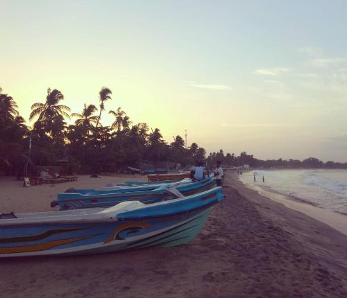 two boats sitting on the beach near the ocean at Beach View in Arugam Bay