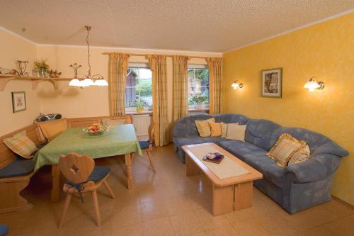 a living room with a blue couch and a table at Ferienhof Hübner in Bad Berneck im Fichtelgebirge