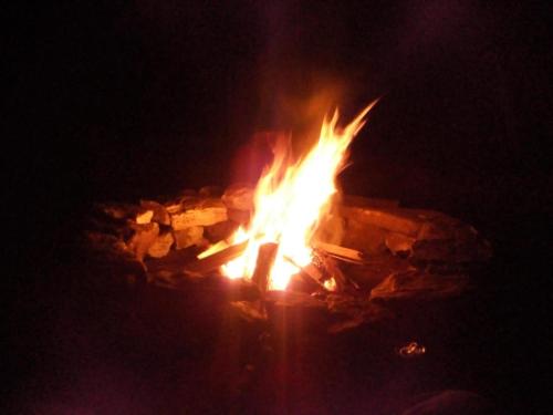 a fire burns in a pile of rocks at night at chales azaleia todos in São Bento do Sapucaí