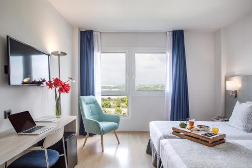a hotel room with a bed and a desk with a laptop at Augusta Barcelona Vallès in Granollers
