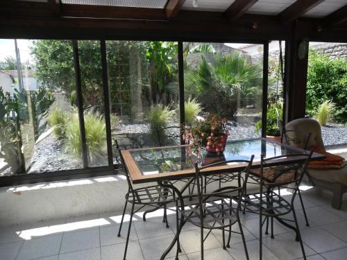 une table et des chaises en verre sur la terrasse dans l'établissement La Luzacaise, à Saint-Just