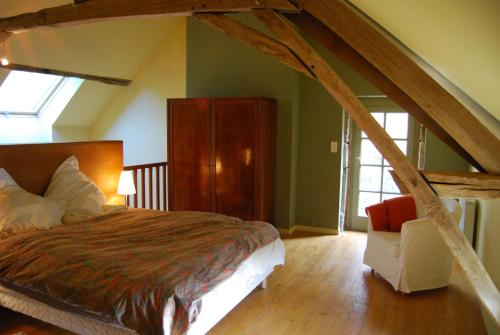 - une chambre avec un grand lit et une chaise dans l'établissement La Tour, à Marcilly-la-Gueurce