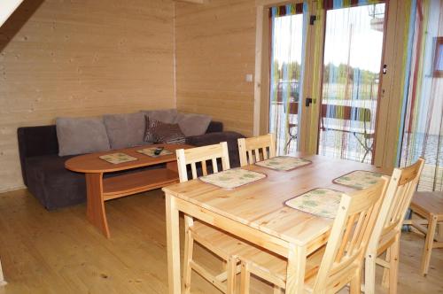 a living room with a table and a couch at Villa Amber in Sarbinowo