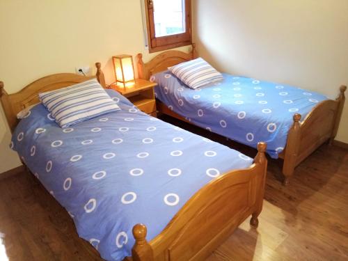 - deux lits assis l'un à côté de l'autre dans une pièce dans l'établissement Apartamento Mirador Del Puigmal, à Puigcerdà