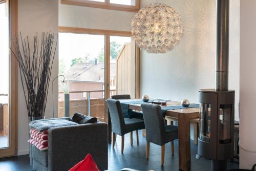 a dining room with a table and chairs and a chandelier at Chalet Apartments Iseltwald in Iseltwald