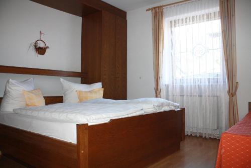 a bedroom with a large bed with a window at Haus Vierjahreszeiten in Reit im Winkl