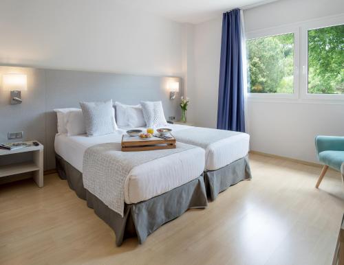a hotel room with two beds and a window at Augusta Barcelona Vallès in Granollers