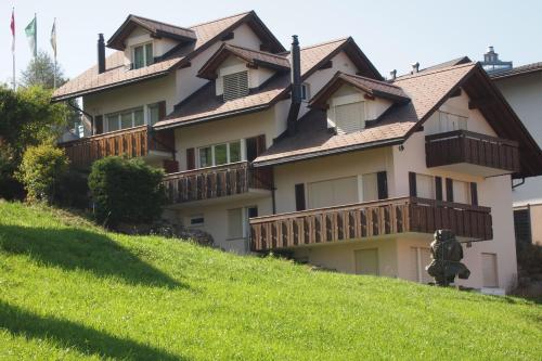 a large house on top of a grassy hill at Haus Flumser-Hockli - CharmingStay in Flumserberg