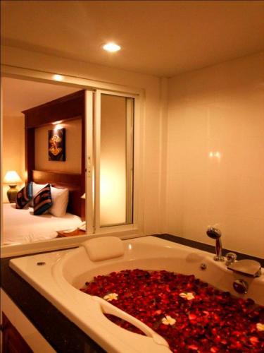 a bathroom with a bath tub filled with red roses at Baan Yuree Resort & Spa - SHA Plus in Patong Beach