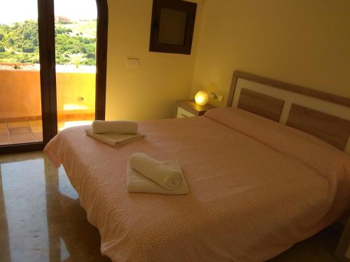 馬尼爾瓦的住宿－Coto Real Duquesa，一间卧室配有一张床,上面有两条毛巾